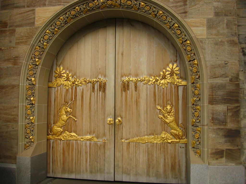 a large wooden gate with gold carvings on it