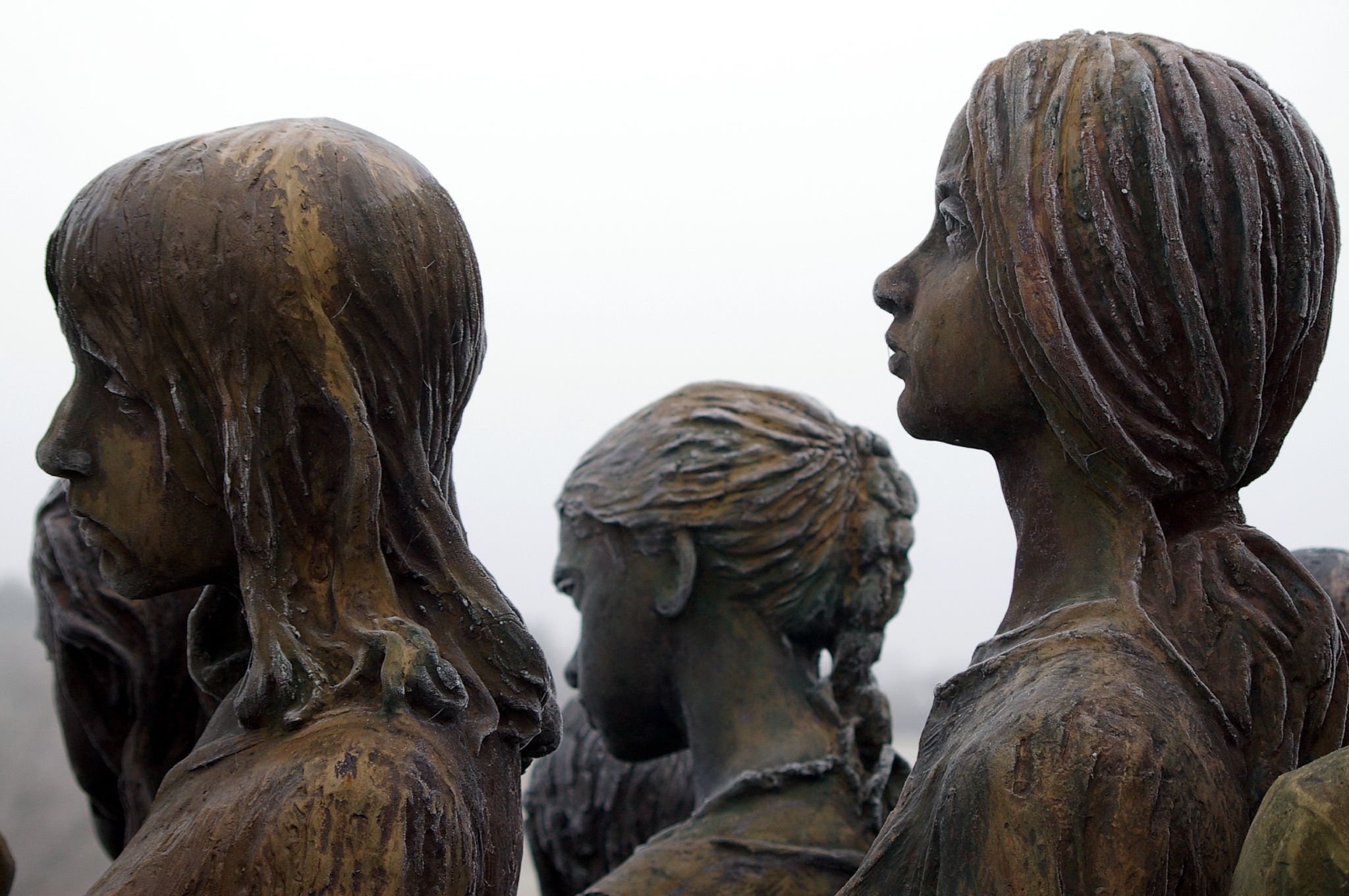 several bronze statues sitting in the middle of a field