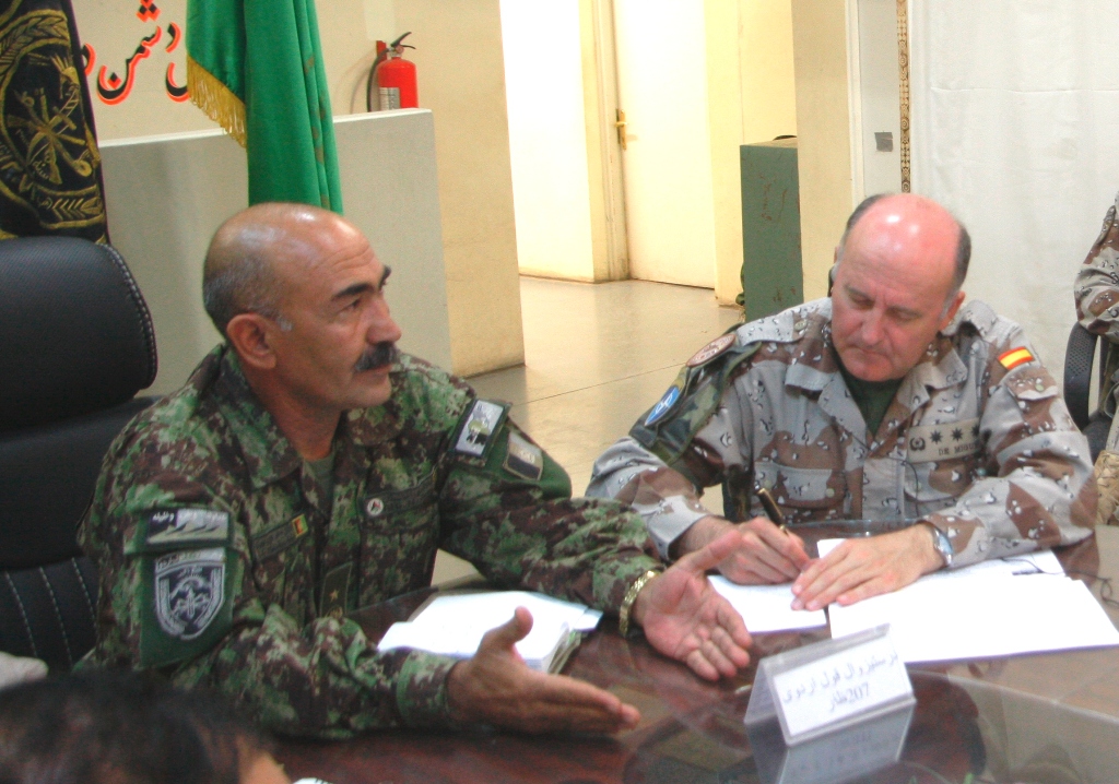 three people sitting at a table signing documents