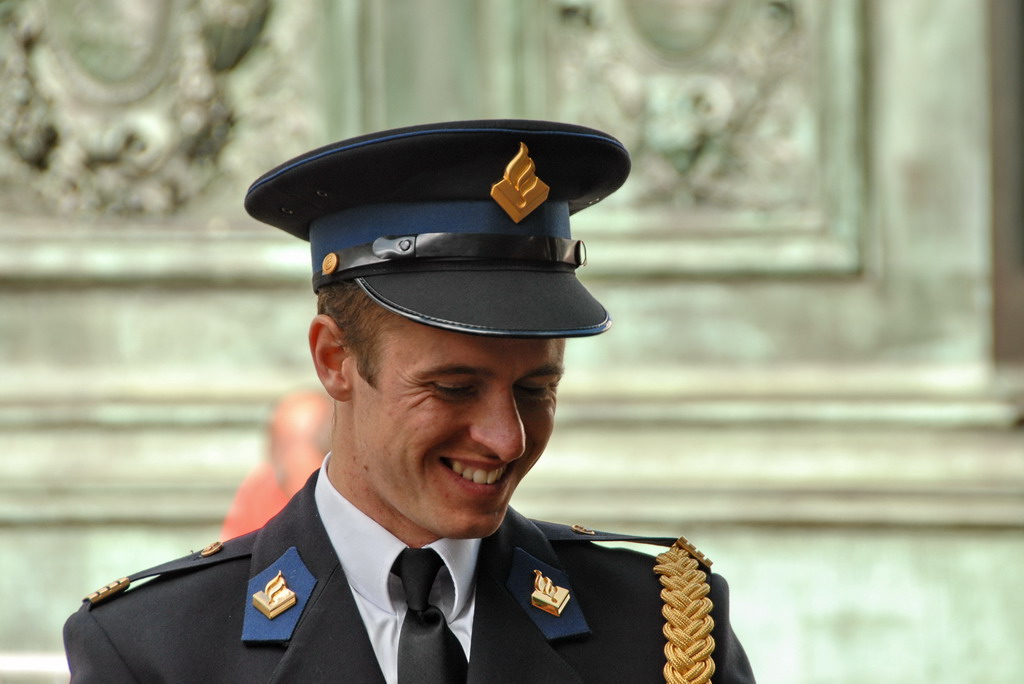 man wearing uniform and smiling and looking away from camera