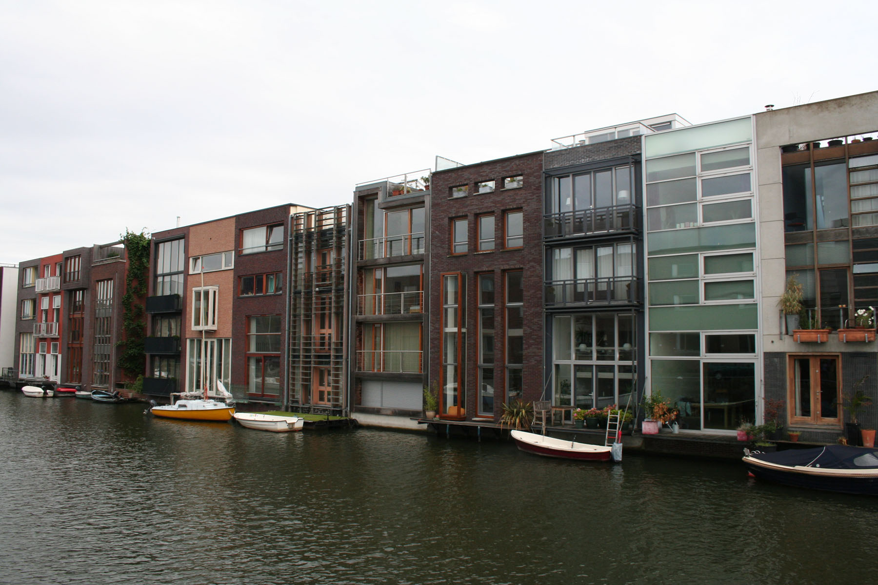 several rows of buildings along a canal near some boats