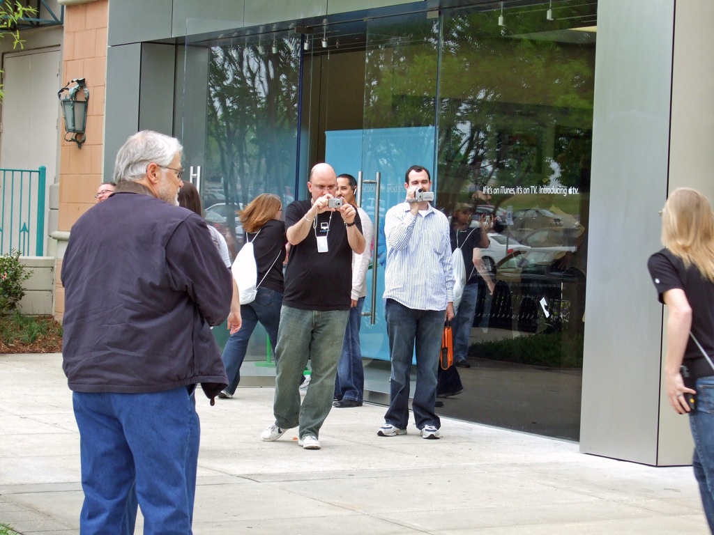 men walking past a large glass store front