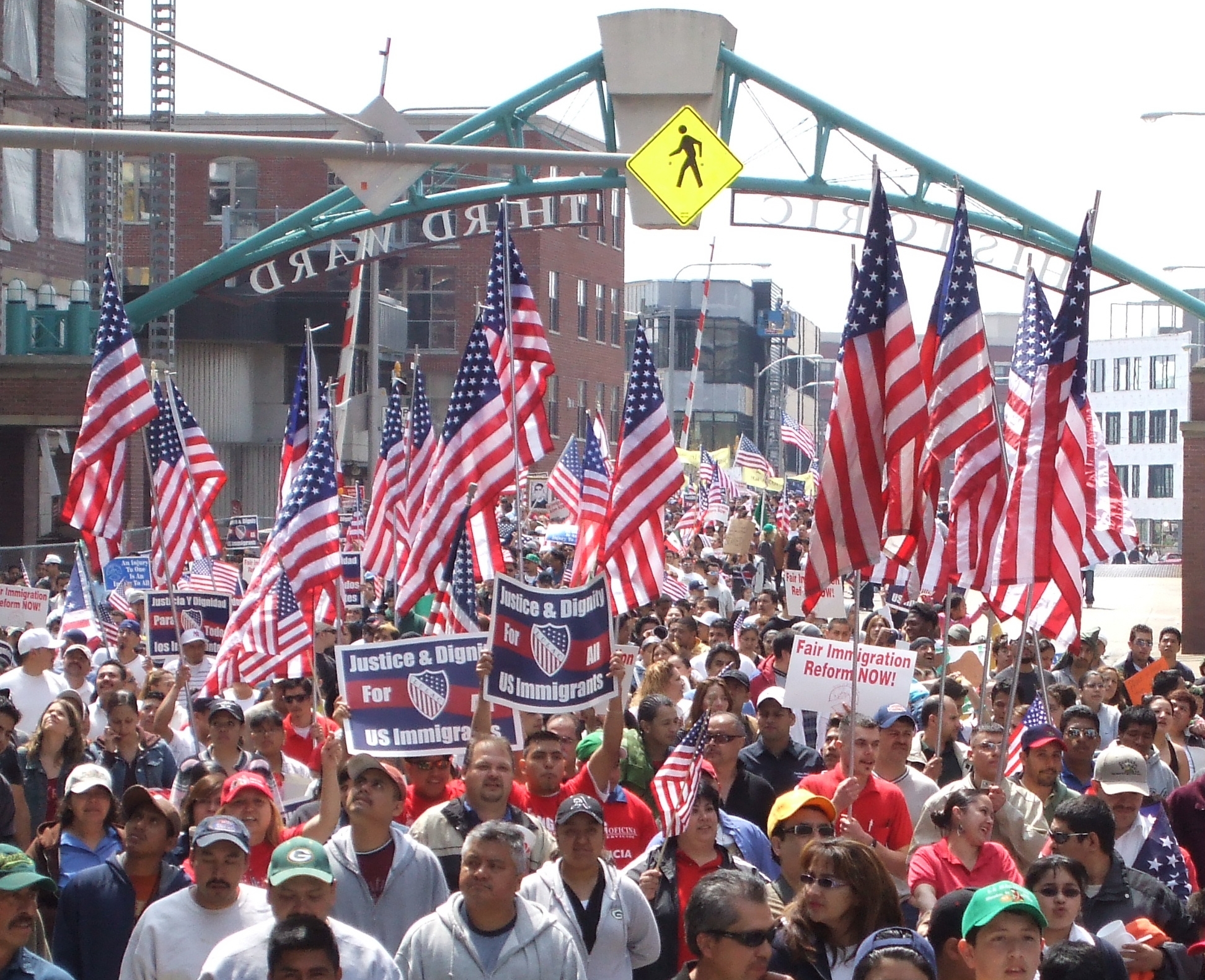 a group of people walking with signs and american flags
