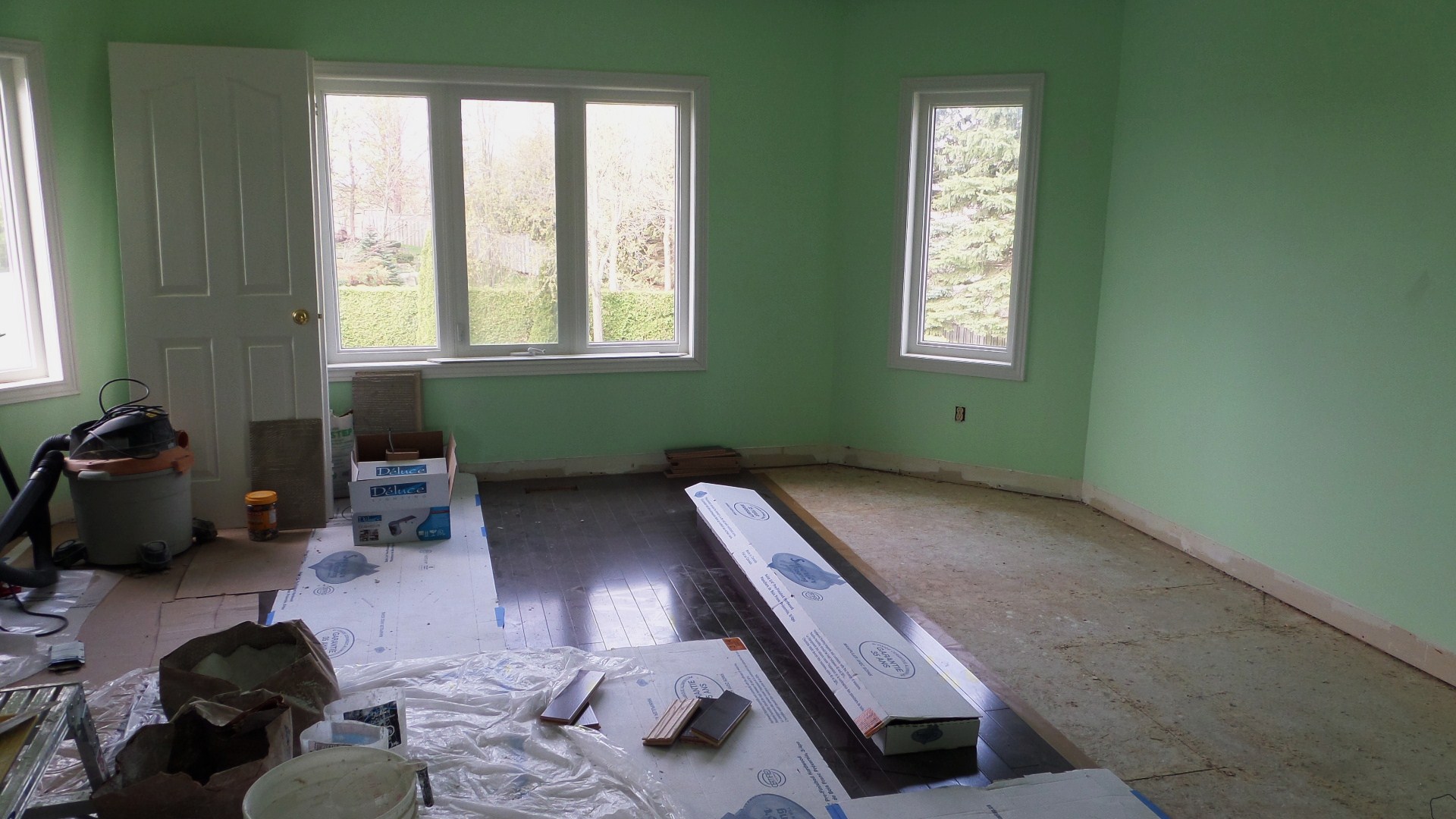 an empty room with windows and paint on the walls