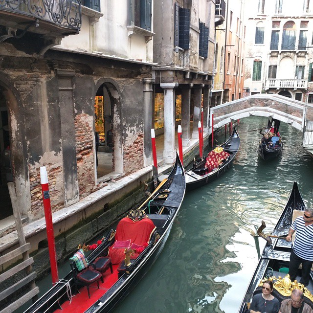 people riding gondolas in an urban street area