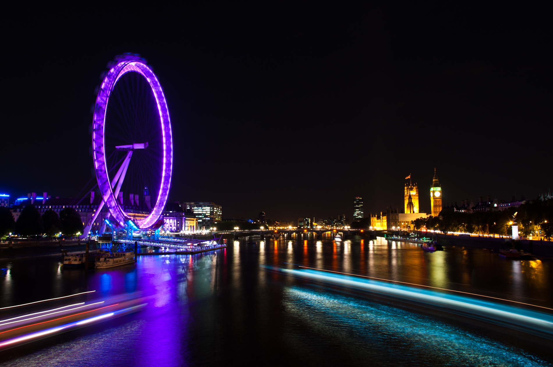 long exposure pograph of a london eye on the river thames at night