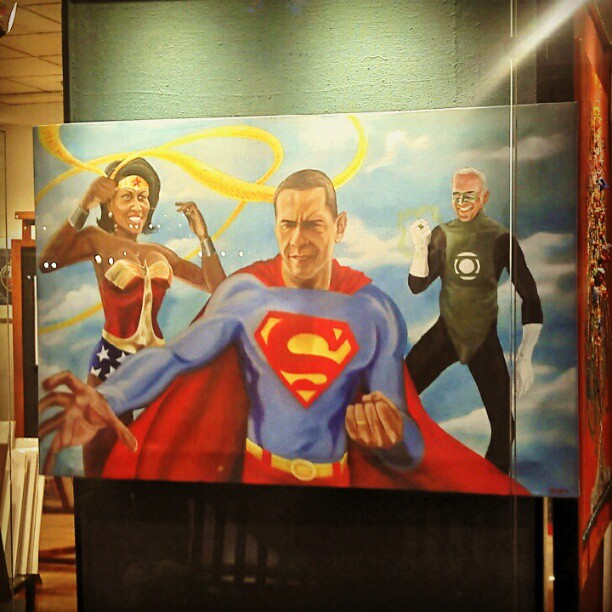 a man in a superman suit next to the painting on a building