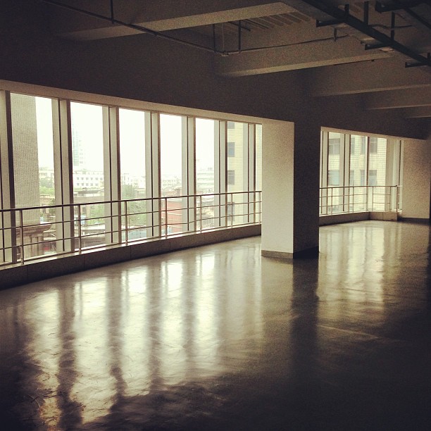 an empty open building with floor to ceiling windows