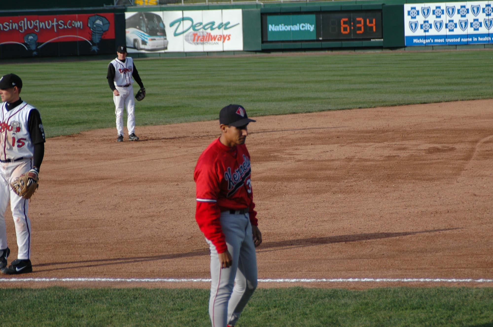 a man holding a baseball glove standing on top of a field