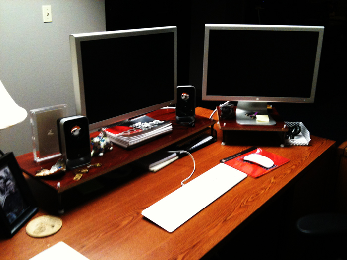 a desk with two monitors, keyboard and mouse