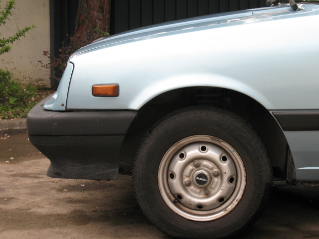 a car with it's tire leaning up on a curb