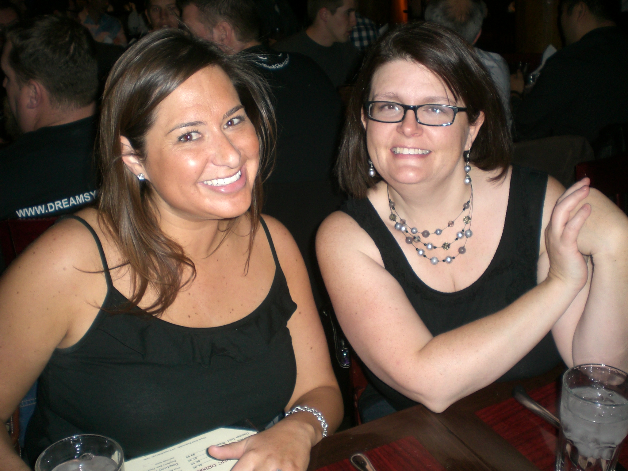 two women sitting at a bar and smiling for the camera