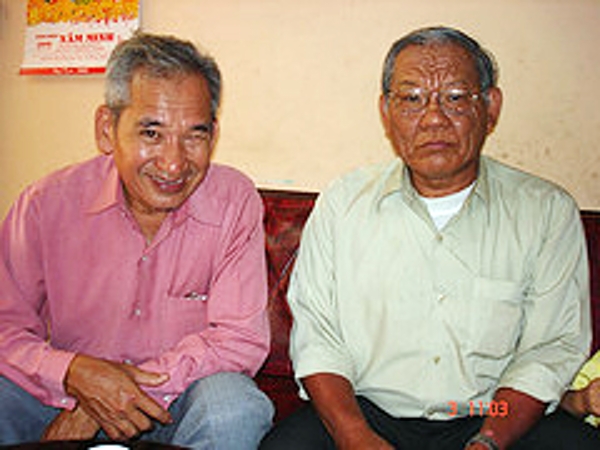 two older men sitting next to each other on a couch