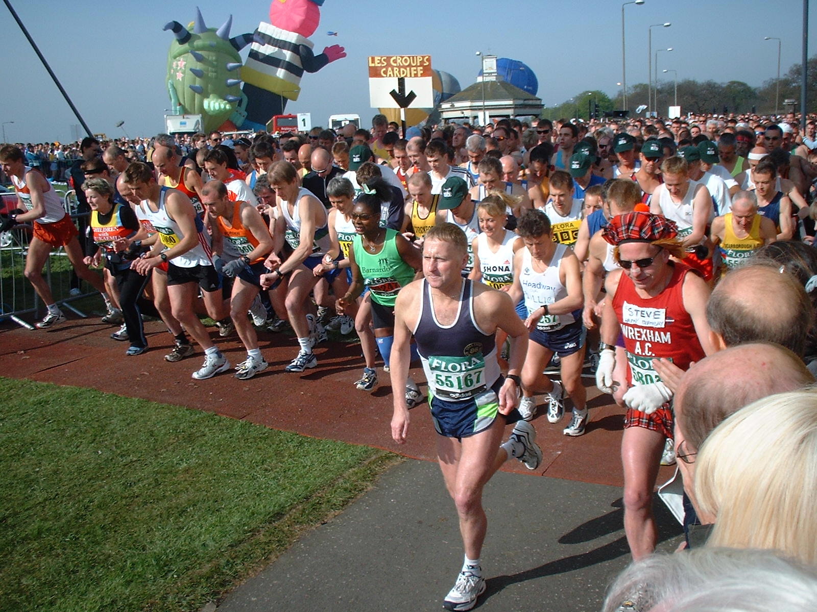 a crowd of runners running on a race track