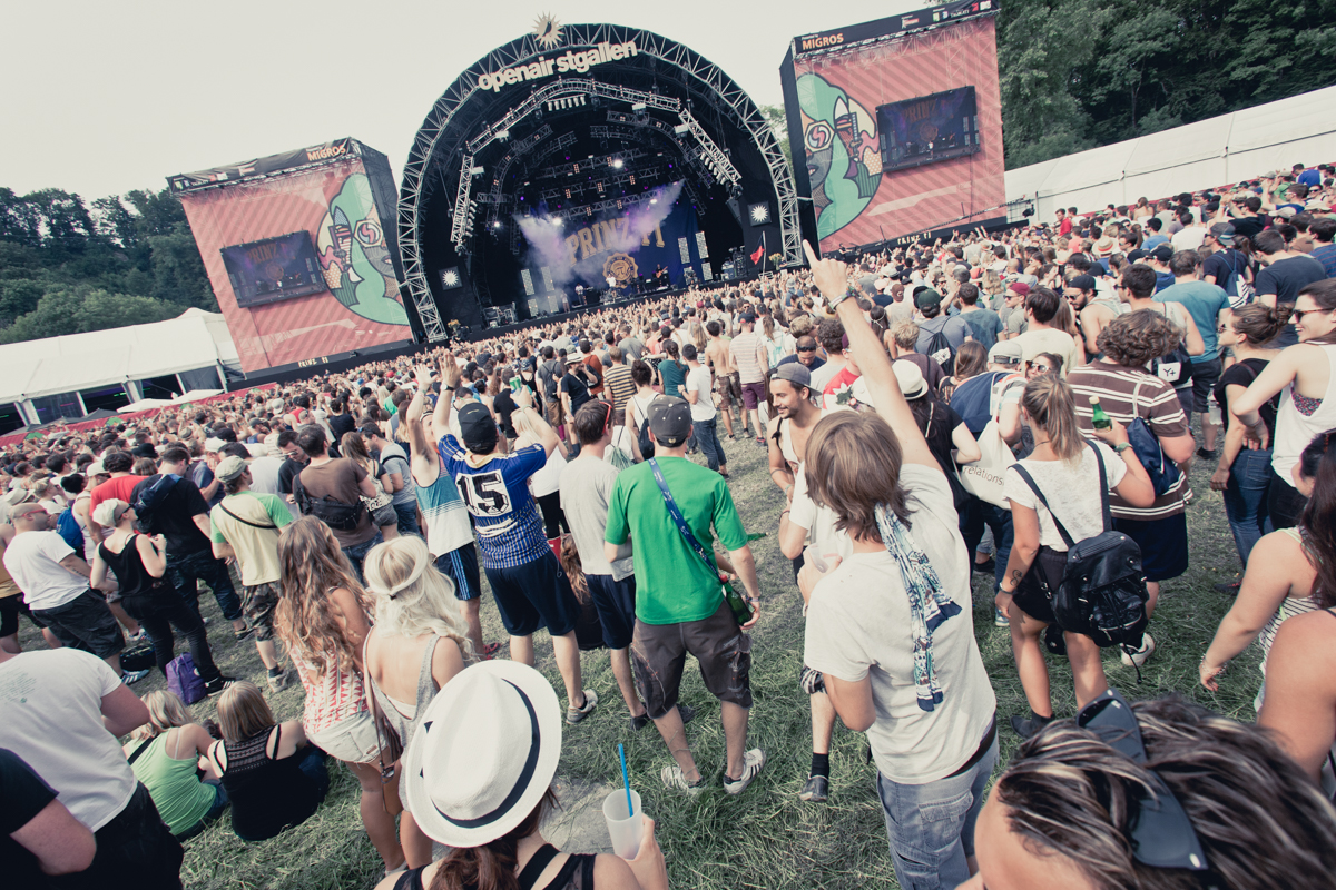 a large group of people standing on top of a lush green field