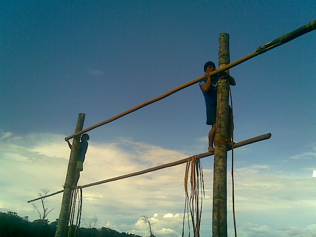two men doing obstacle on wooden poles at the park