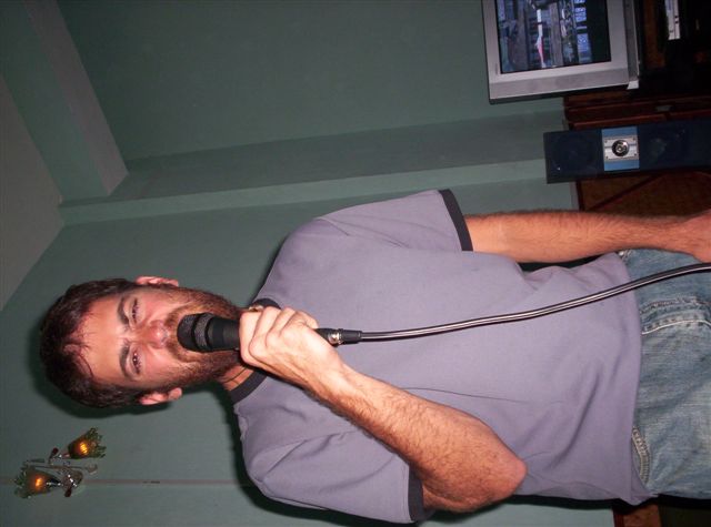 a man plays with a microphone while wearing jeans