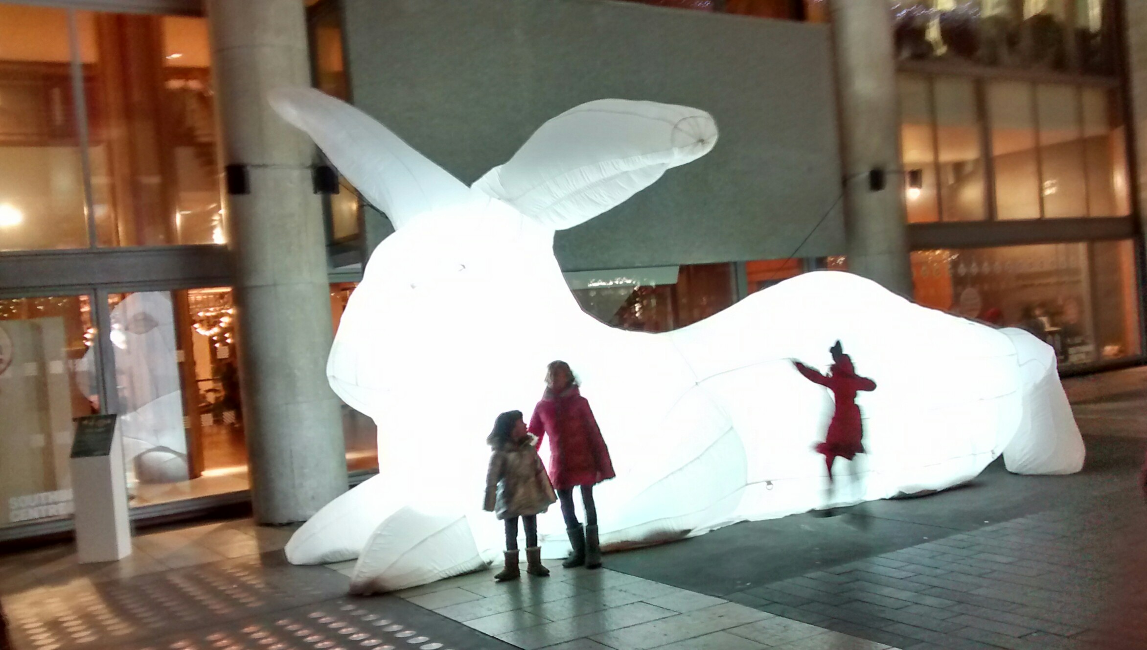 a couple of people stand in front of a giant white piece