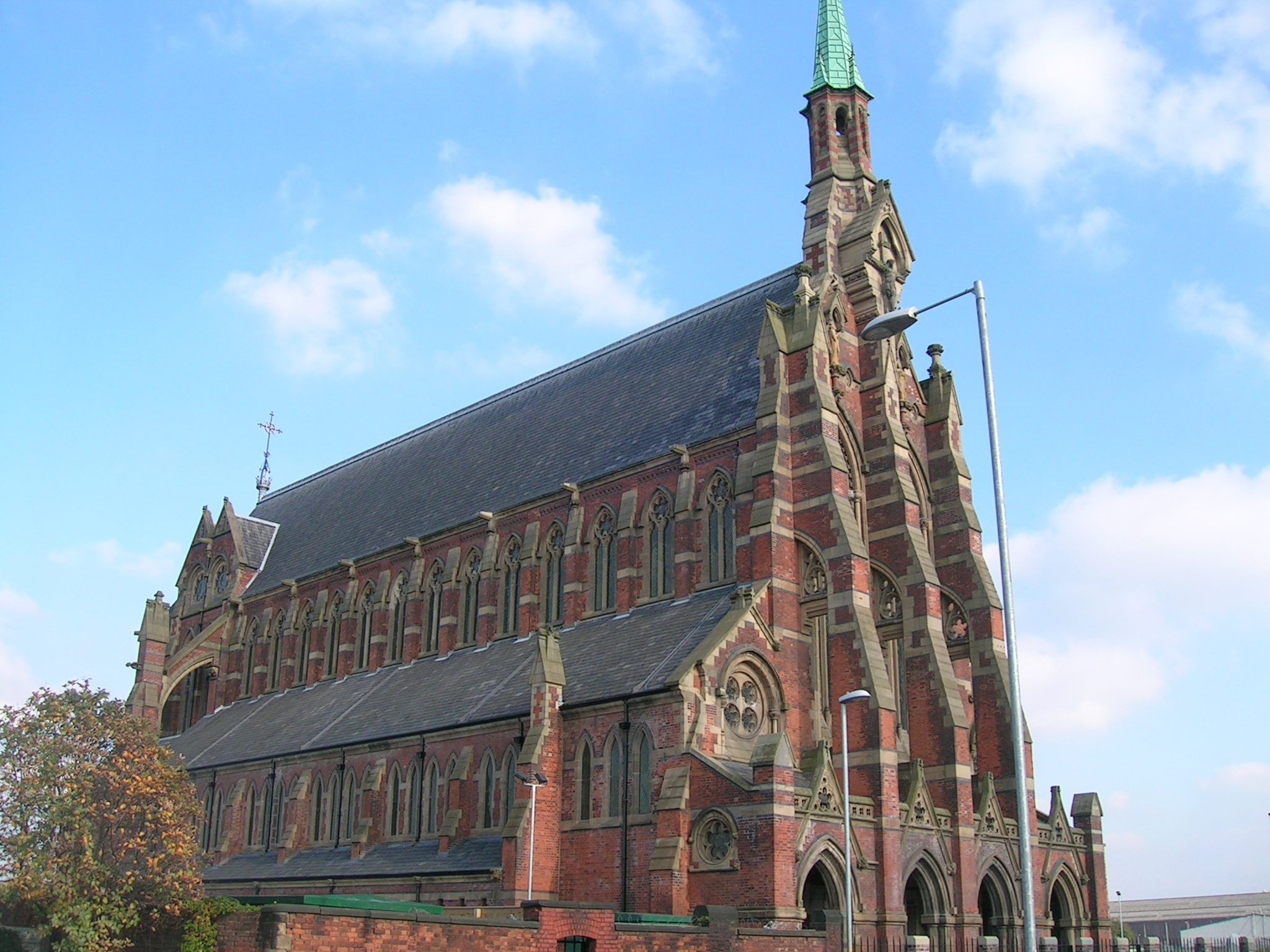 large red brick cathedral with steeple and large clock