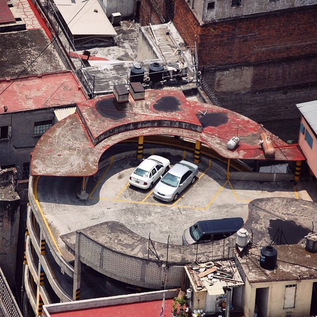 an old and rusty building has two vans in the center