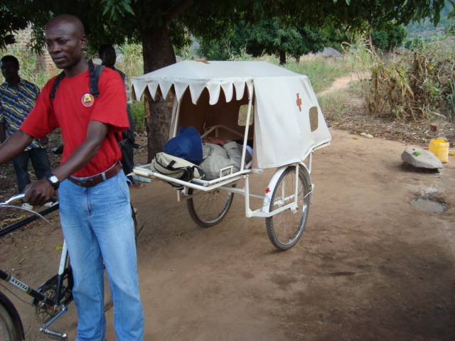 man standing next to bicycle with white trailer