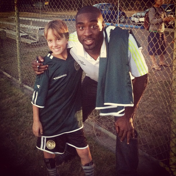 a man and a boy standing next to each other on a soccer field