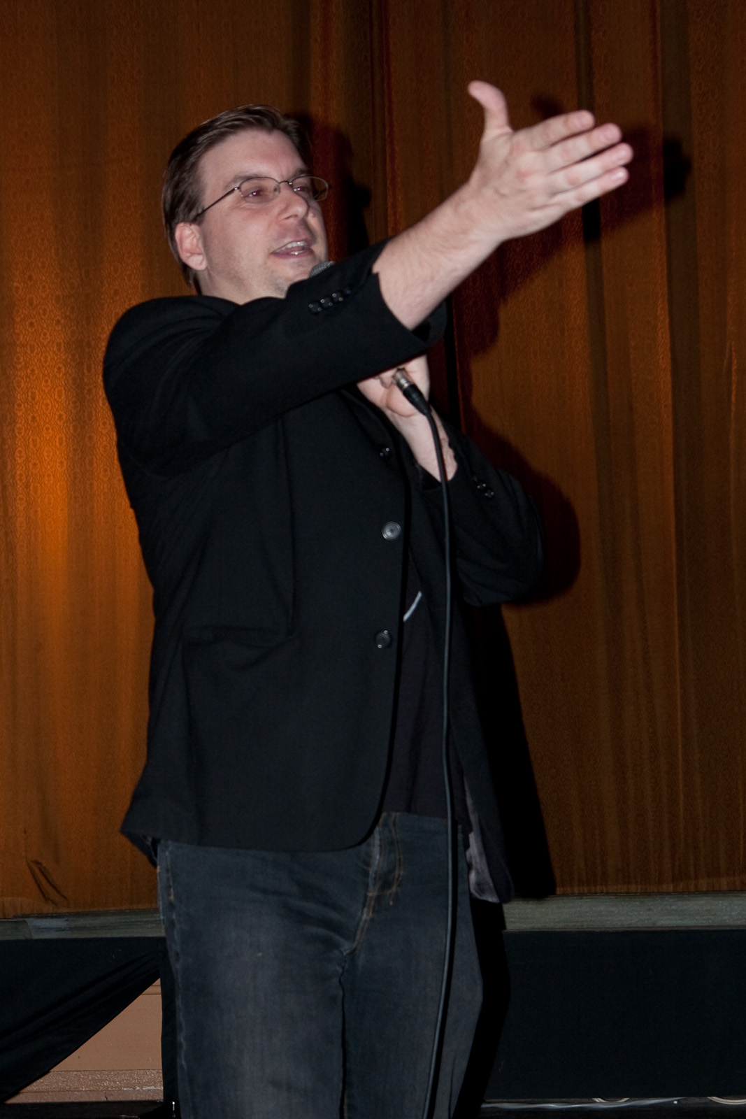 a man standing with a microphone behind his back