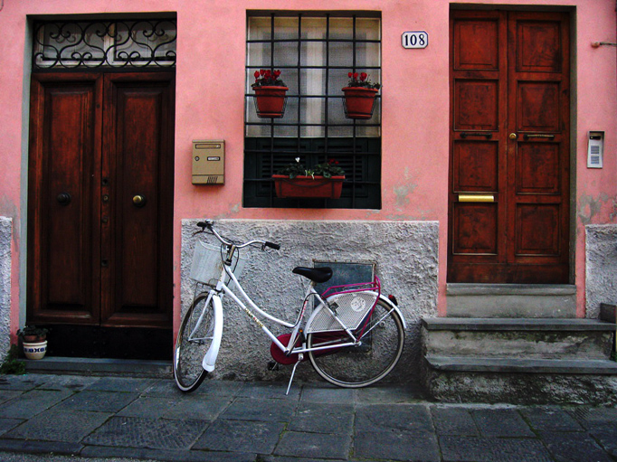 a bicycle leaned against the wall in front of a building
