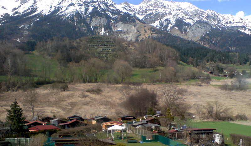 snow capped mountains and small village surrounded by trees