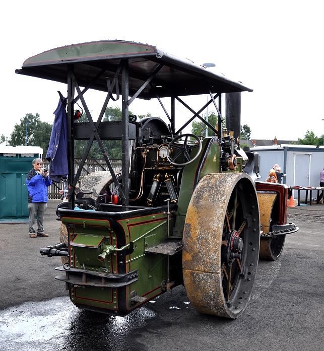 a small green train engine is sitting on tracks