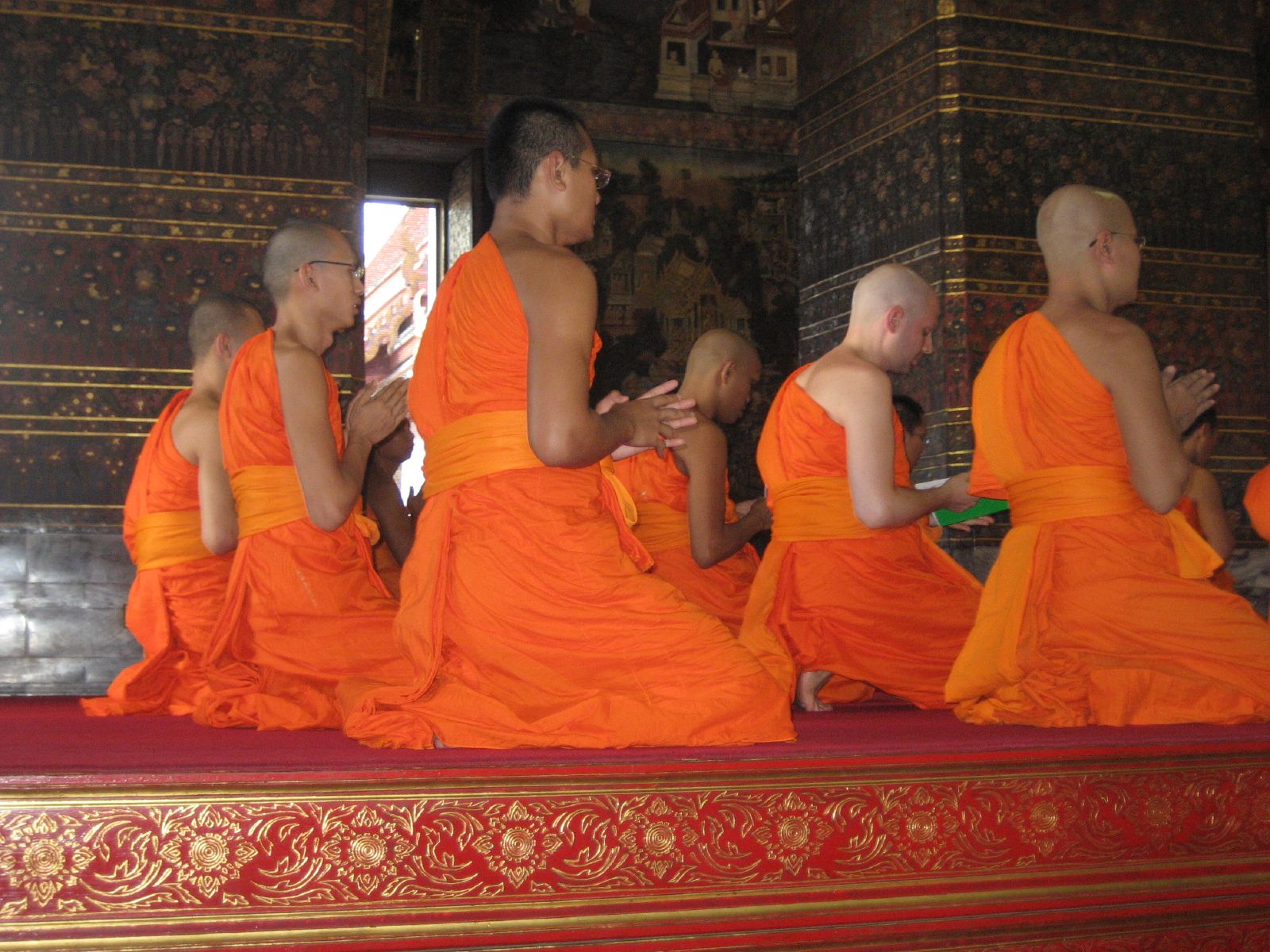 a group of monks dressed in orange sitting on stage