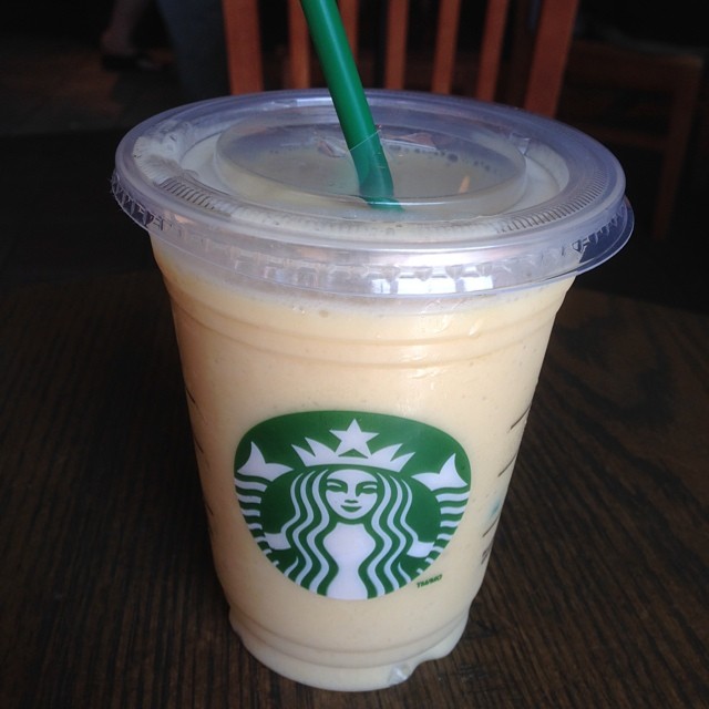 a cup of starbucks beverage with a green straw in it