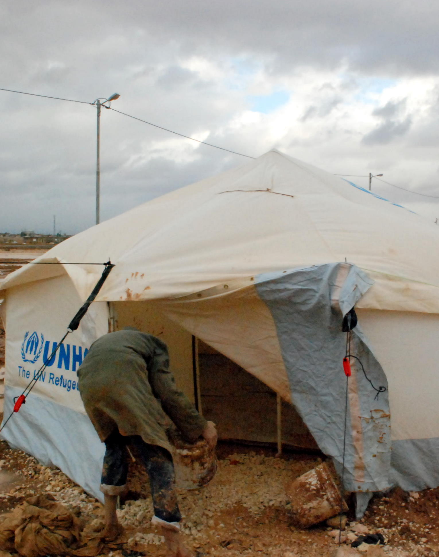 a guy fixing soing in a tent on the ground