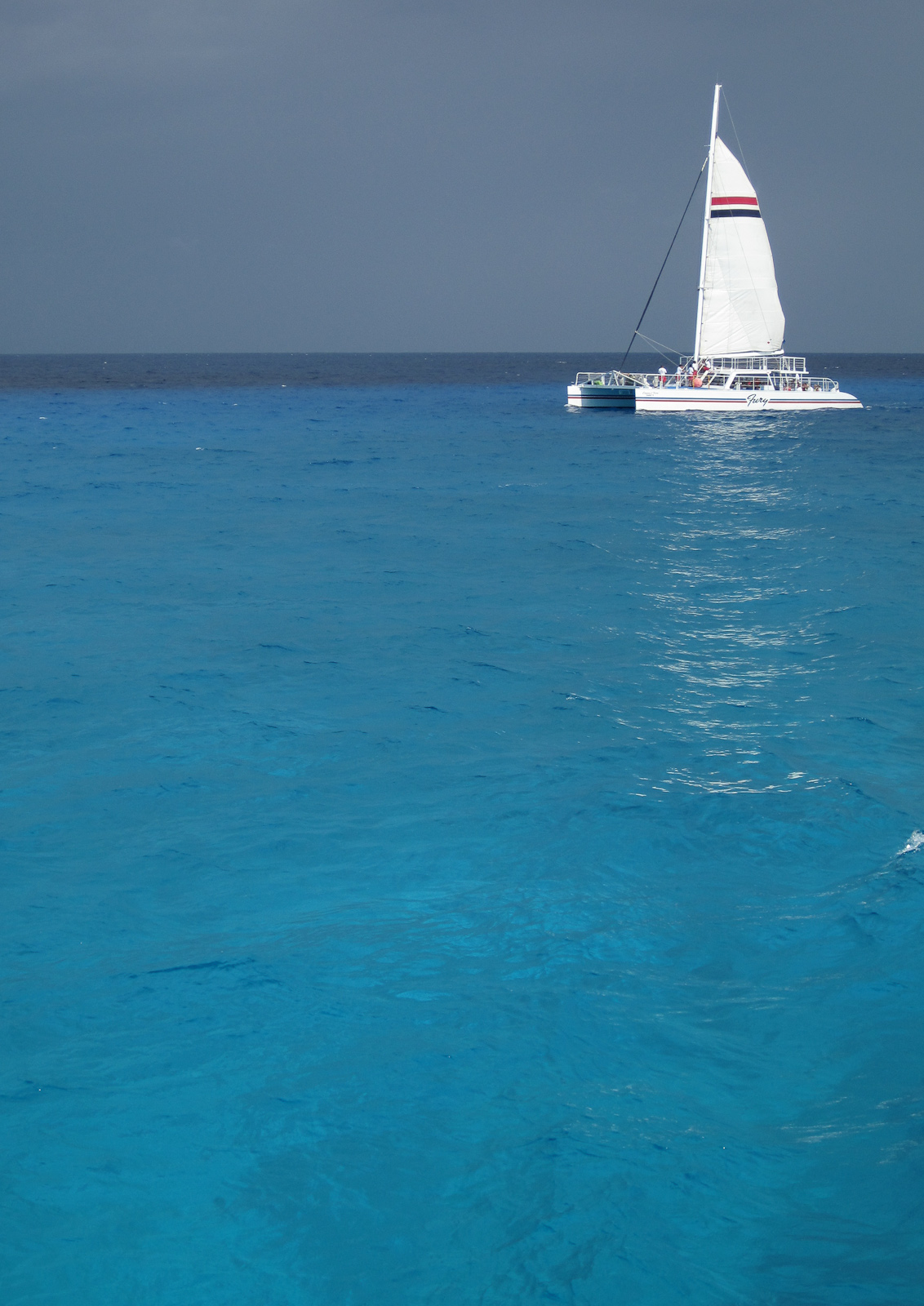 a sail boat is sailing close to the shore