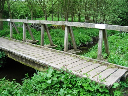the old wooden bridge crosses the small river
