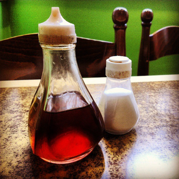 an old style oil bottle on top of a wooden table