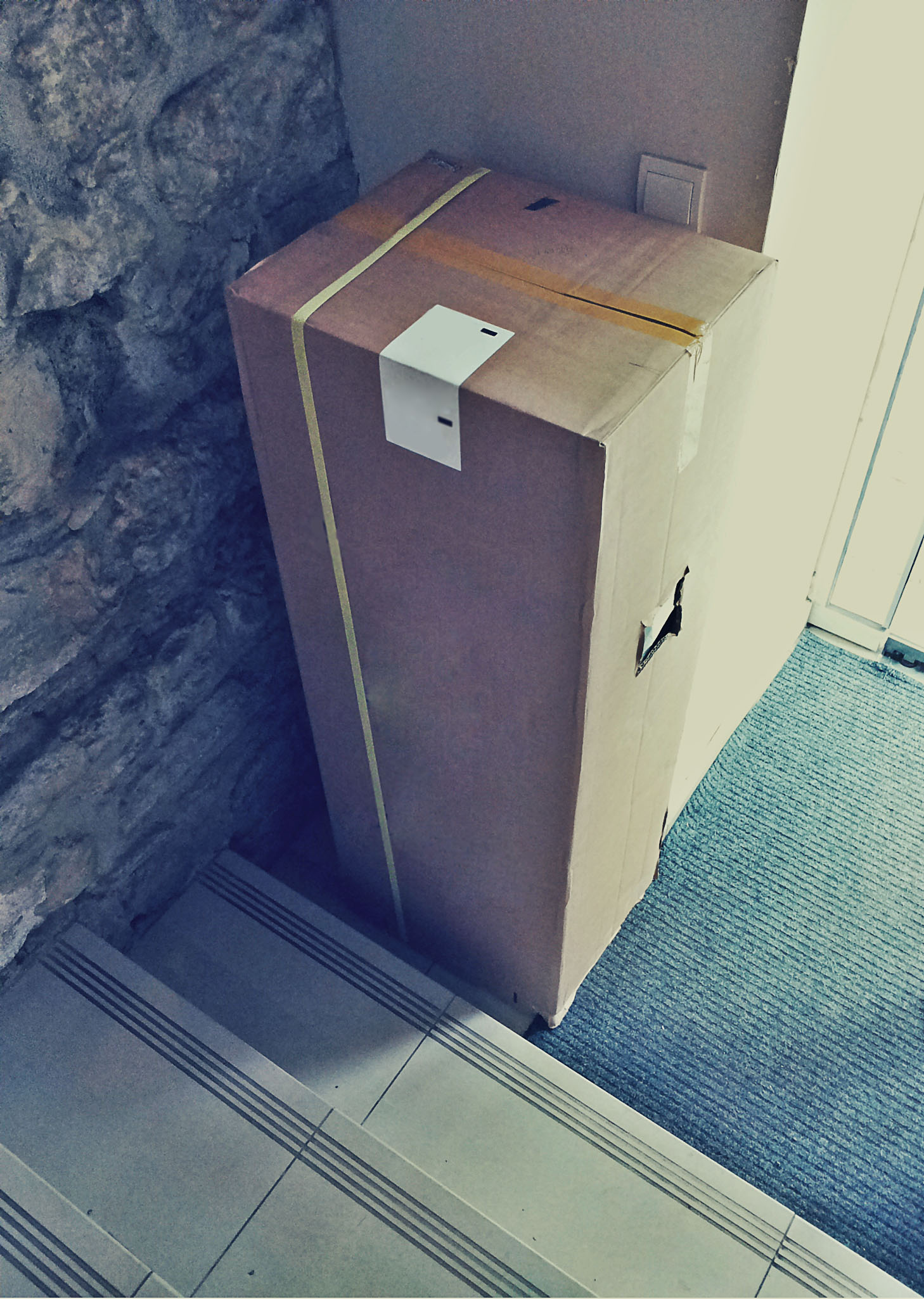 a cardboard box next to a doorway with some stones on it