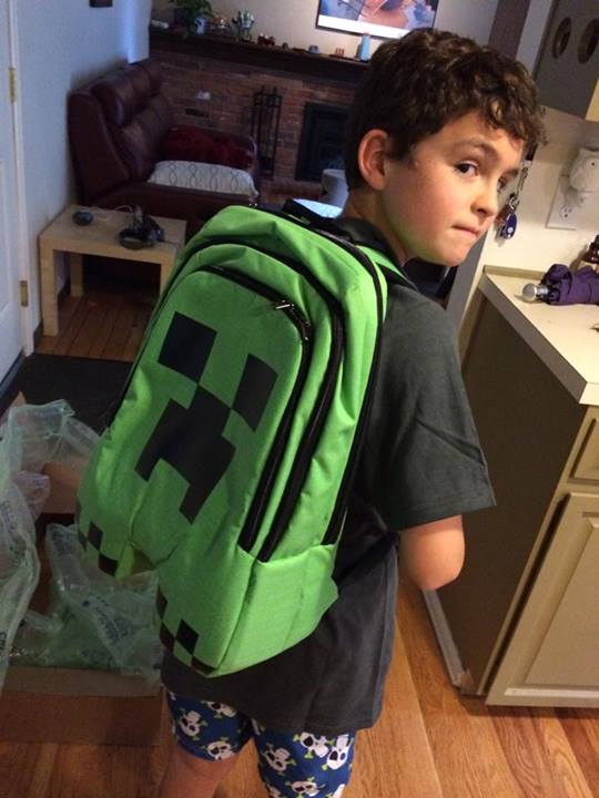 a small boy in a room with a backpack