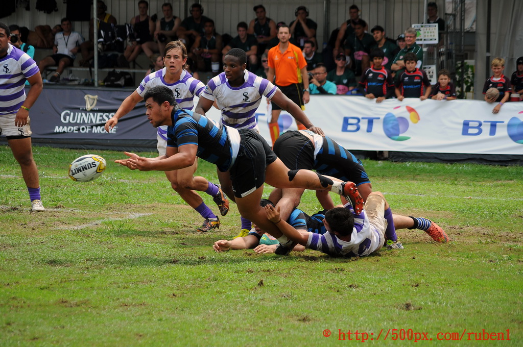 a group of men playing a game of rugby on a field