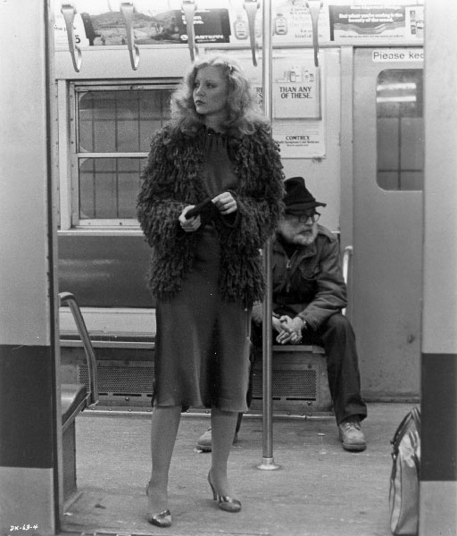 a woman in a fur coat and hat standing on a train platform