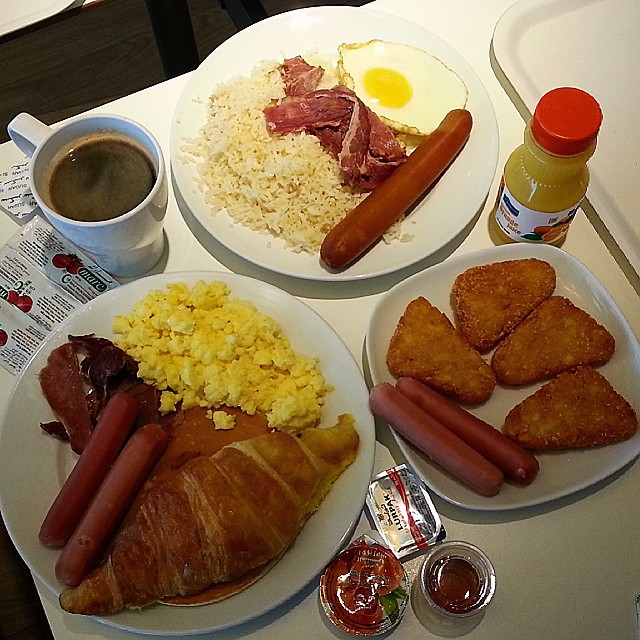 a white tray topped with two plates of breakfast foods