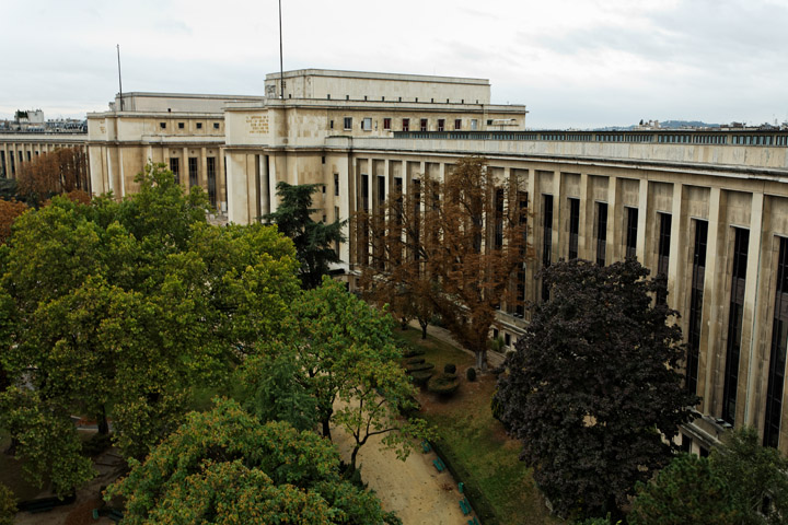 an aerial view of a large building with trees in front