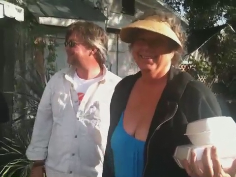 a woman standing next to a man with a drink