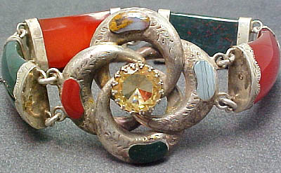 an old silver celet with different colorful stone stones