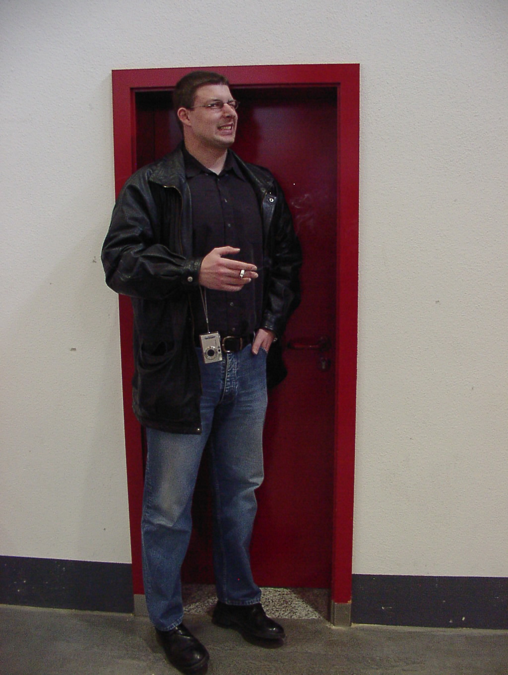 a man standing in front of an open red door