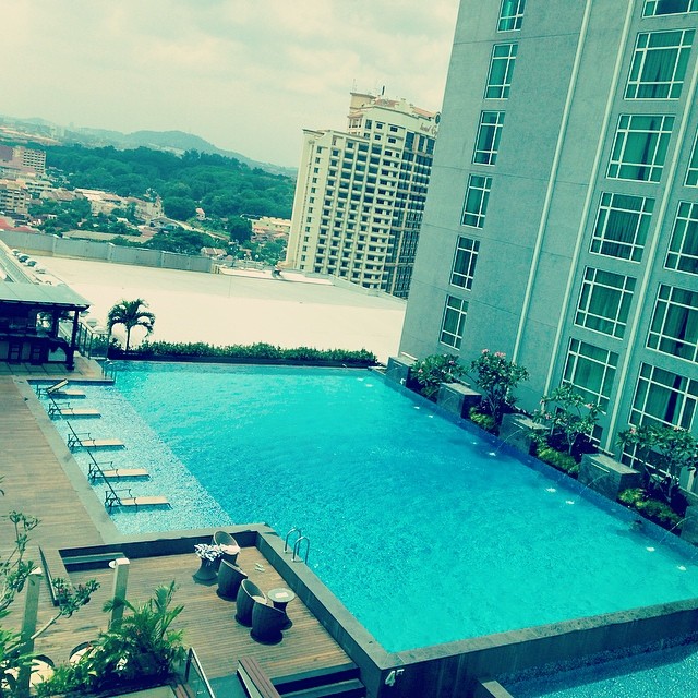 an empty swimming pool with buildings in the background