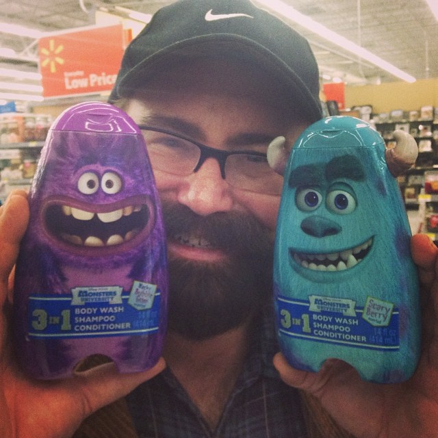 a man holding three toy monsters in a store