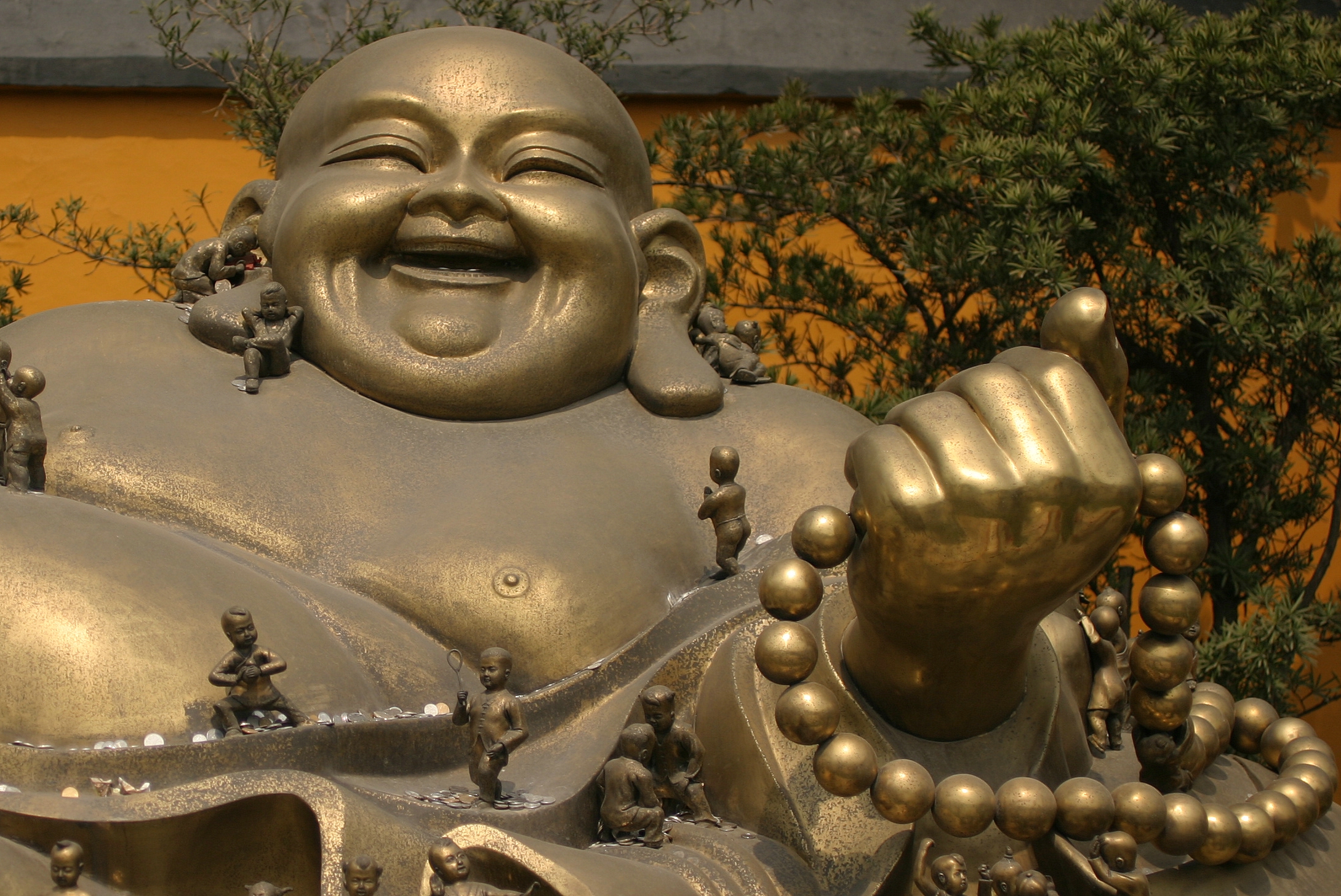 a large metal statue of a laughing buddha
