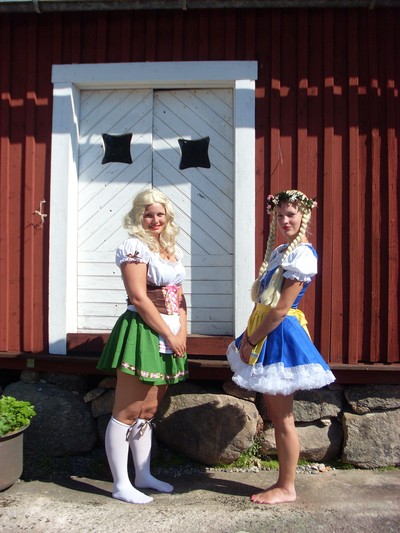 two woman dressed in traditional scottish garb with a door