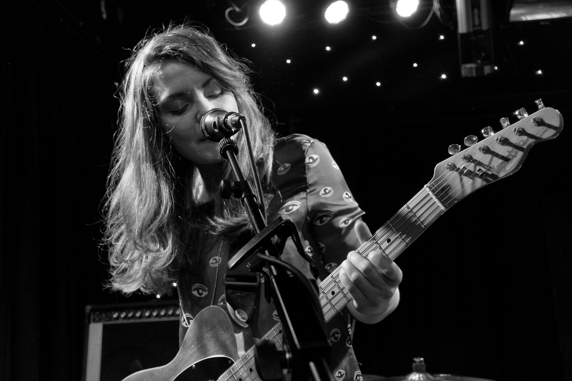 a woman playing the guitar on a stage